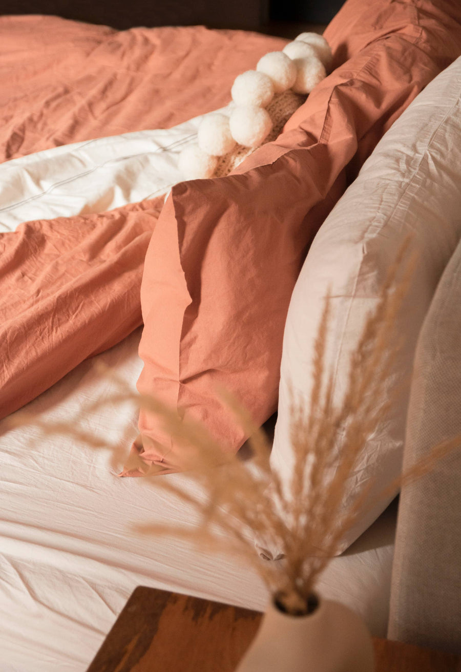 Close-up of a bed with pink bedding and decorative elements.